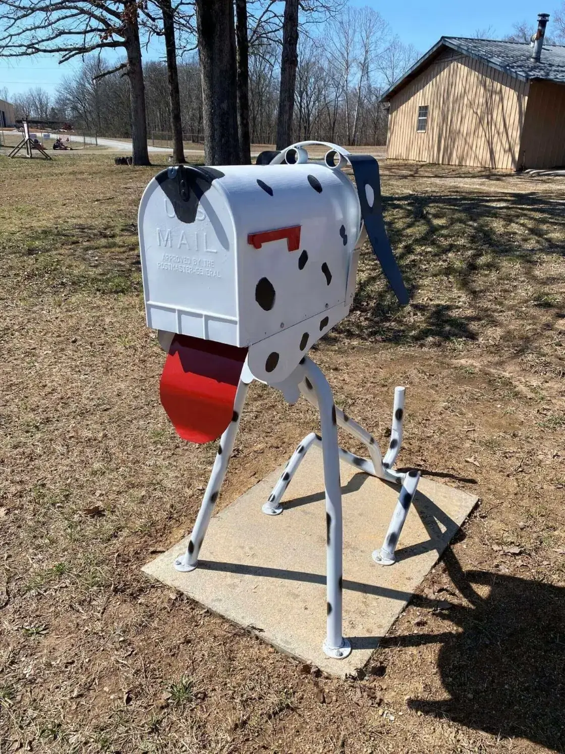 Dog-shaped mailbox with red tongue.