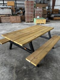 Wooden picnic table with black metal legs Wooden picnic table in warehouse with crates